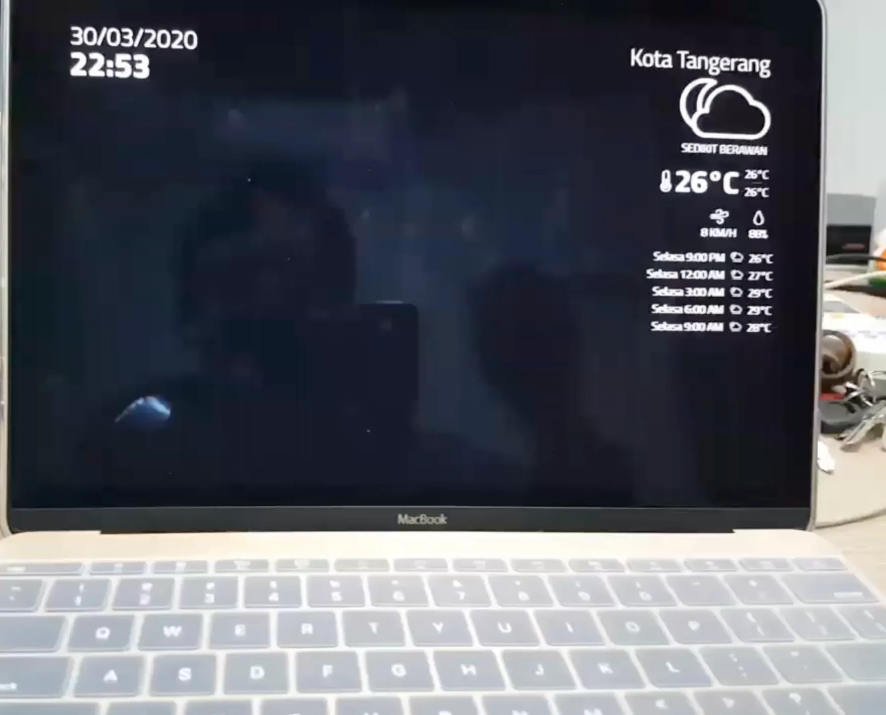 The prototype display showing a clock and weather information on a laptop.