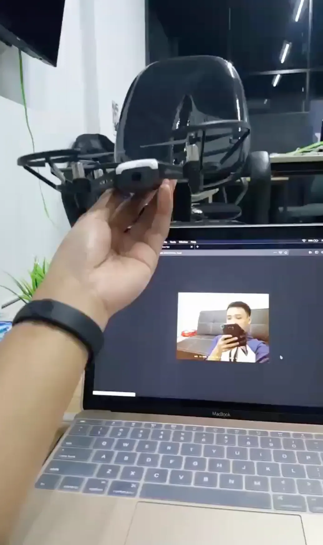 My Tello held in front of a laptop showing its camera feed.
